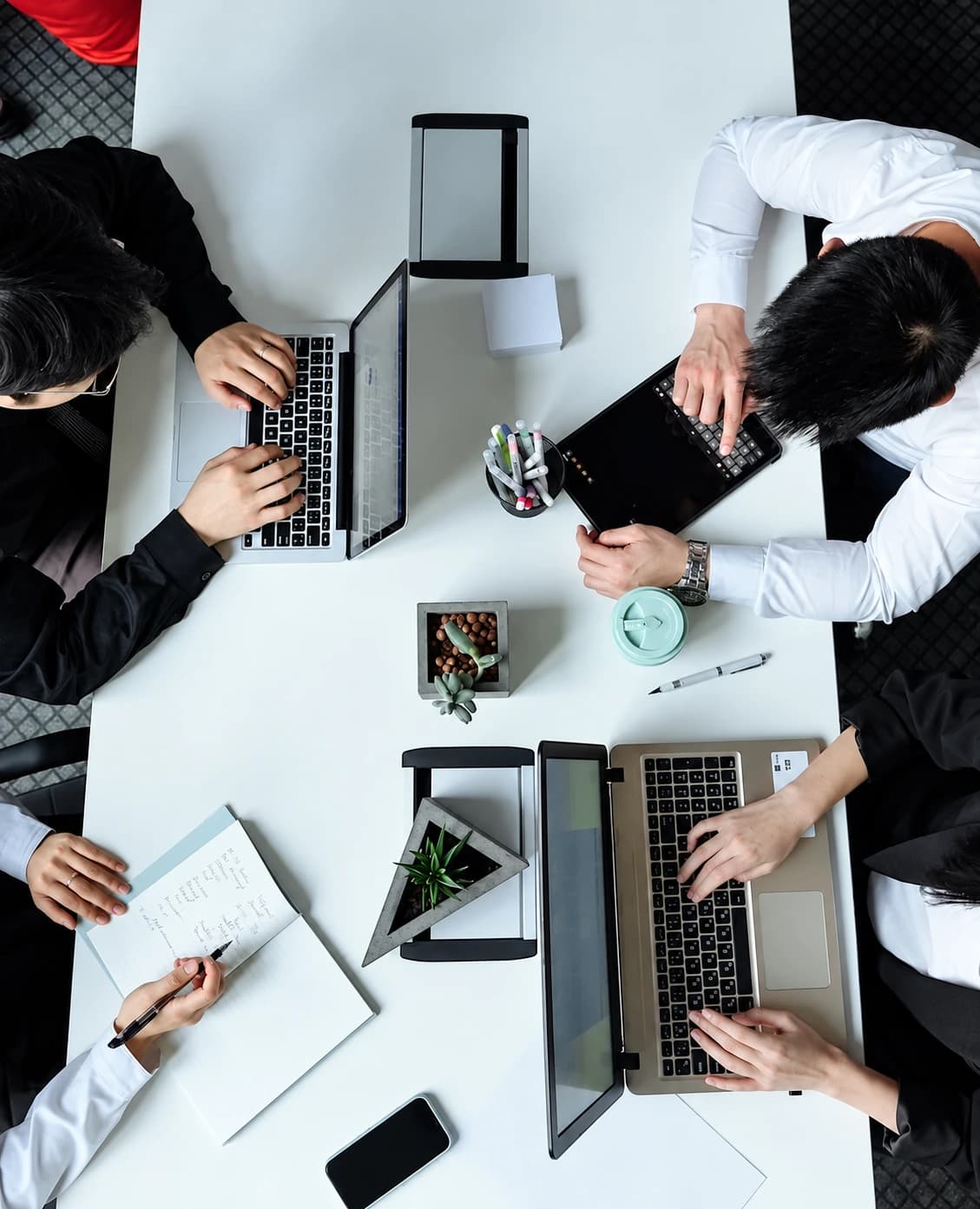 Team collaborating around laptops during a workflow design session